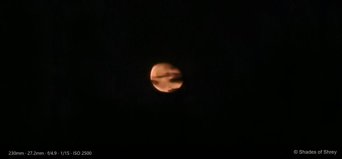 Amber moon veiled by dark clouds