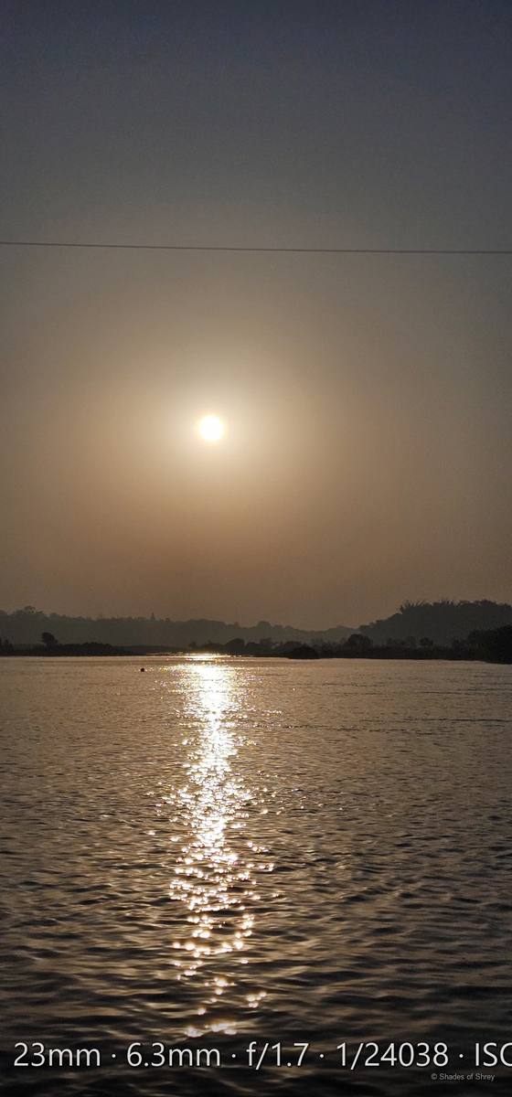 Sun shimmering over misty waters at dawn