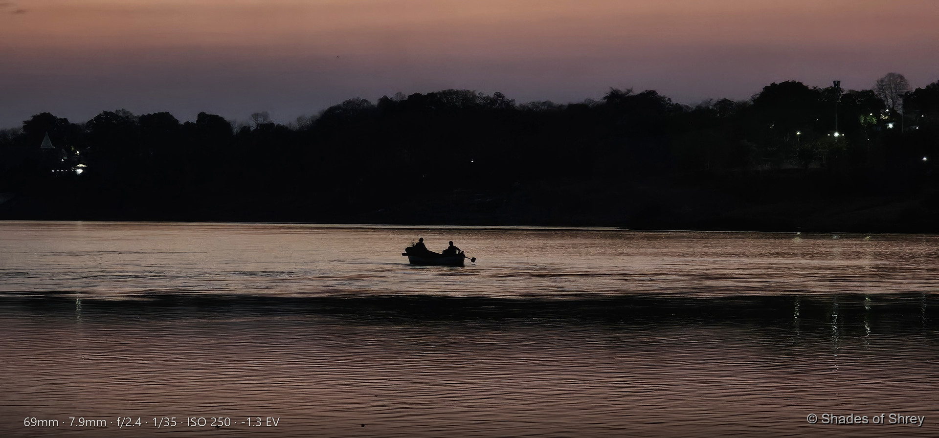 Silhouetted boat on river at twilight