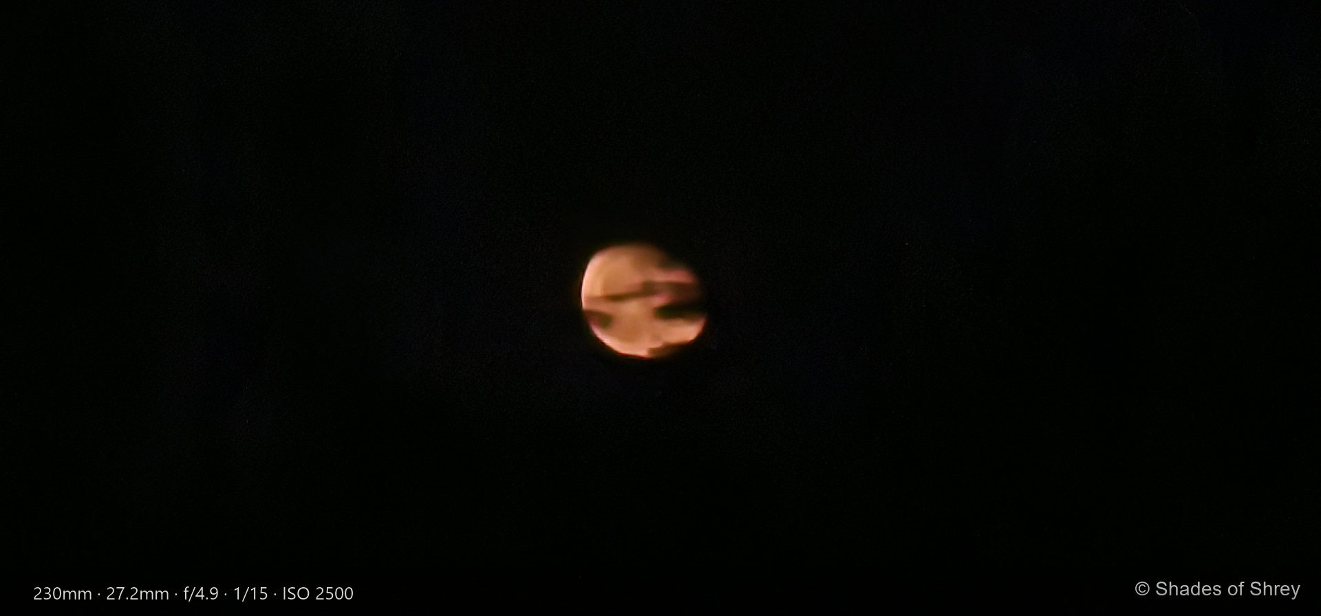 Amber moon veiled by dark clouds