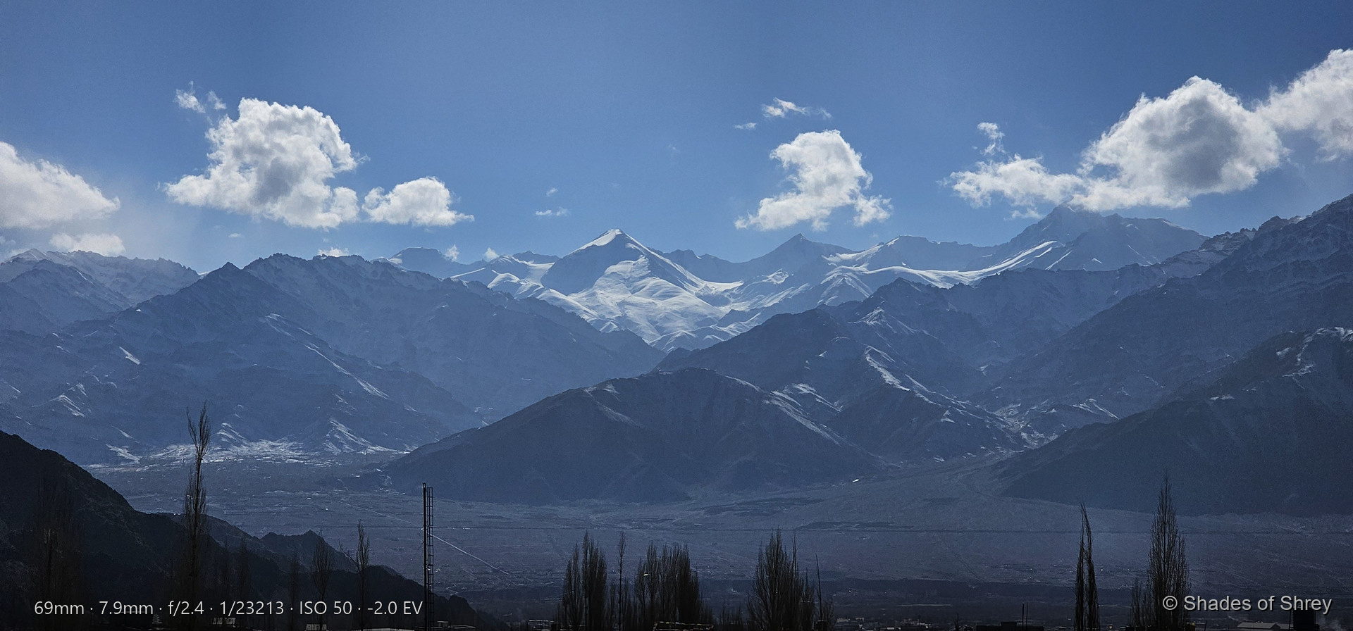 Panoramic snow-capped mountain range under blue sky