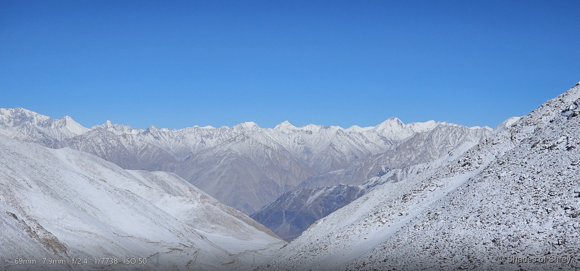 Pristine white snow pass with distant Himalayan peaks
