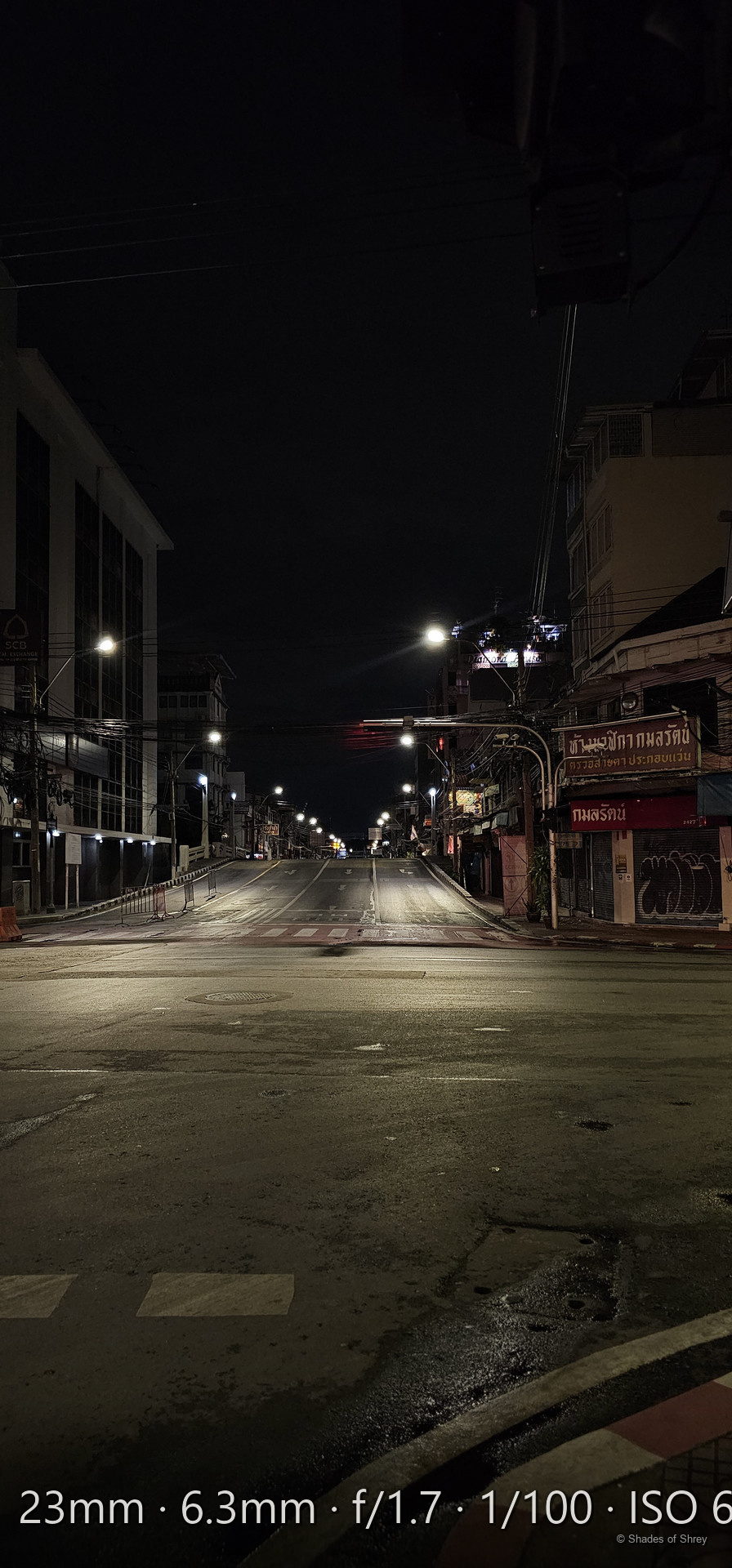 Bangkok street at night with Thai signage and warm streetlights