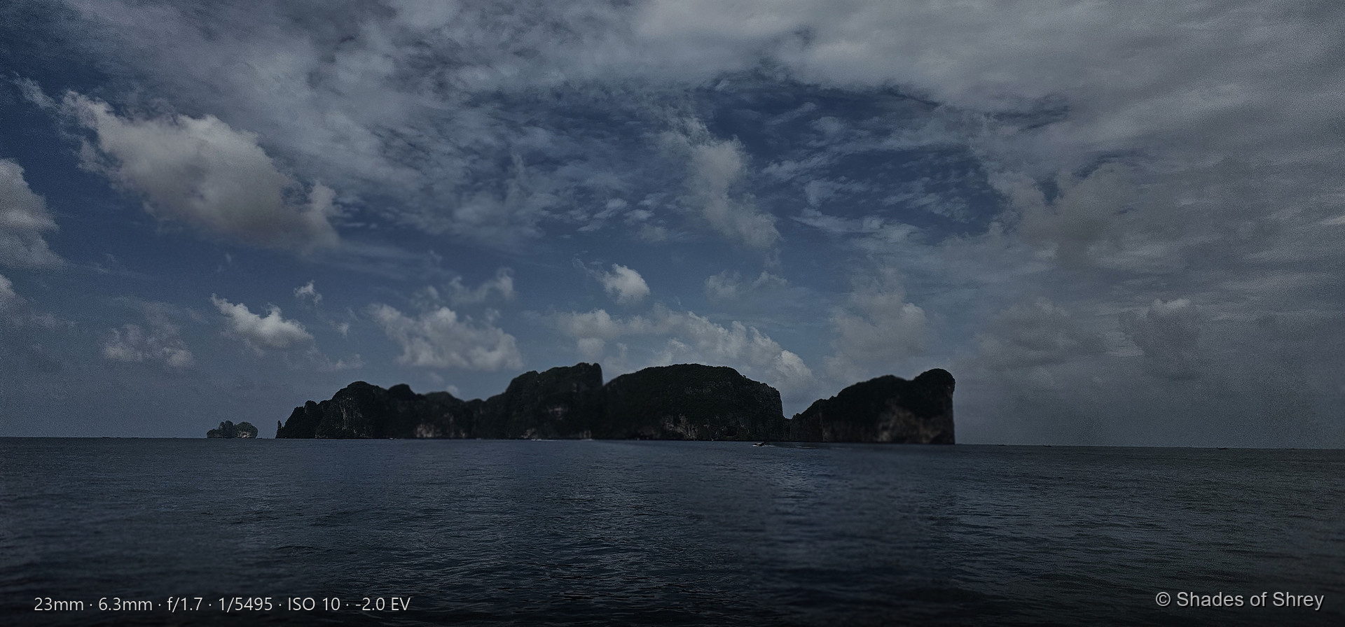 Phi Phi Islands silhouette rising from the Andaman Sea under dramatic blue sky
