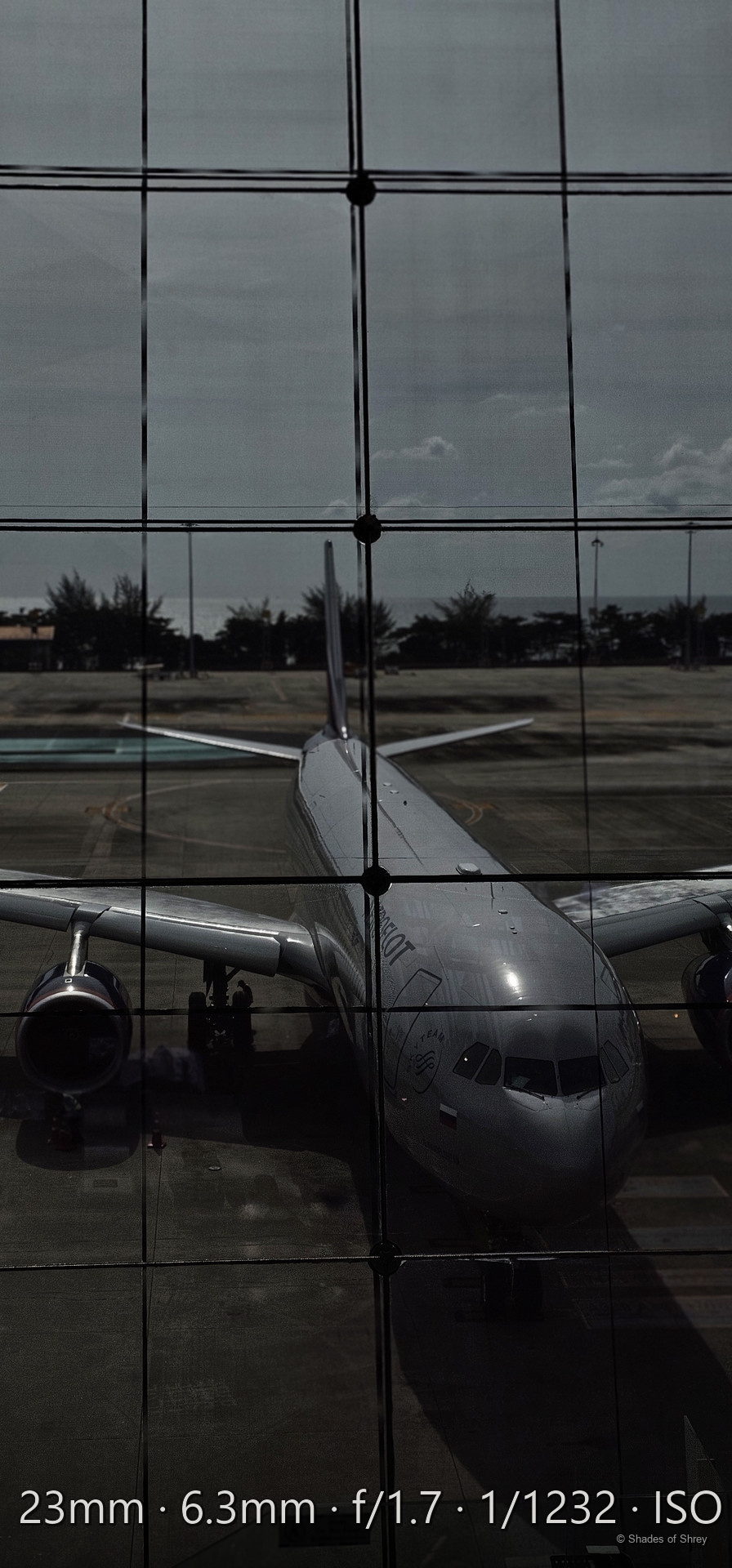 Aircraft reflected in the glass wall of an airport terminal